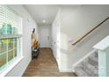 Bright hallway with wood-look flooring and a staircase leading to the upper level at 5063 Beargrass Dr, Dallas, NC 28034