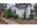 Side view of a white house with gray brick base and landscaping at 5917 Peach St, Charlotte, NC 28269