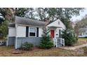 Front view of a white house with red door, gray brick base, and landscaping at 5917 Peach St, Charlotte, NC 28269