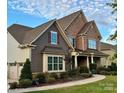 Two-story home with stone and shingle accents, attached garage, and manicured lawn at 6022 Candlestick Ln, Lancaster, SC 29720