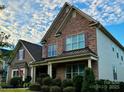 Two story home with stone and shingle accents, welcoming porch, and landscaped lawn at 6022 Candlestick Ln, Lancaster, SC 29720