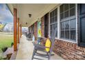 Brick front porch with rocking chairs and sunflowers at 6751 Lackey Rd, Vale, NC 28168