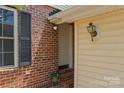 Charming front entrance with brick accents, siding, and decorative lighting at 7019 Walnut Ridge Ct, Charlotte, NC 28217