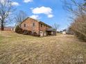 Brick home with attached garage and deck, nestled on a hillside at 7392 Reeps Grove Church Rd, Vale, NC 28168