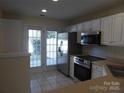 Bright kitchen featuring stainless steel appliances, white cabinets, and tiled floors at 8620 Robinson Forest Dr, Charlotte, NC 28277