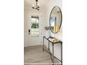 Bright entryway showcasing a glass-paneled front door, round mirror, and modern console table, enhancing curb appeal at 9957 Cask Way, Huntersville, NC 28078