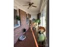 Sunroom with terracotta tile floor, wicker chair, and plants at 108 Greenview Dr, Kannapolis, NC 28081