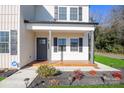 Covered front porch with wood flooring and gray door at 114 E 5Th Ave, Gastonia, NC 28052