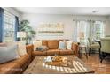 Spacious living room with a brown leather sectional sofa and a wooden coffee table at 114 E 5Th Ave, Gastonia, NC 28052