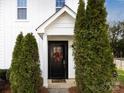 Close-up of a black front door, framed by greenery, with a festive wreath at 1509 B Briar Creek Rd, Charlotte, NC 28205