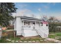 White bungalow with a porch, steps, and American flag at 203 Linwood Rd, Kings Mountain, NC 28086