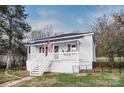 White house with porch and steps, American flag visible at 203 Linwood Rd, Kings Mountain, NC 28086