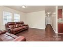 Spacious living room features a supple leather sofa, wood floors, and bright natural lighting at 208 Lakewood Ave, Charlotte, NC 28208