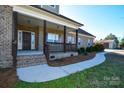 Brick front porch with dark brown door and wooden railing at 2610 Lucy Short Cut Rd, Marshville, NC 28103