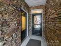 Front entry with stone walls and a black door at 3020 Sewee Ln, Waxhaw, NC 28173