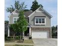 Inviting home with stone accents, a two-car garage, and a charming front porch with manicured landscaping at 3020 Sewee Ln, Waxhaw, NC 28173
