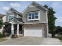 Charming two-story home boasts stone accents, a two-car garage, and a quaint front porch at 3020 Sewee Ln, Waxhaw, NC 28173