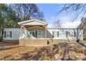 Light blue mobile home with covered porch and rocking chairs at 7933 Cherry Point Dr, Denver, NC 28037