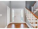 Bright entryway with hardwood floors, staircase, and white door at 9435 Squirrel Hollow Ln, Charlotte, NC 28720