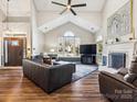 Spacious living room featuring hardwood floors, fireplace, and vaulted ceilings at 10705 Whitfield Ridge Dr, Charlotte, NC 28277