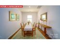 Bright dining room featuring hardwood floors, a wooden table, seating for four, and stylish decor at 11127 Cardinal Creek Ave, Charlotte, NC 28215