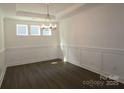 Bright dining room boasts hardwood floors, modern chandelier and decorative wall trim at 1136 Yellow Springs Dr, Huntersville, NC 28078