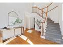 Bright foyer with hardwood floors, staircase, and stylish decor creates a welcoming entrance at 11805 Farnborough Rd, Huntersville, NC 28078