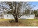 Single story home with a tree in front and deck at 1515 Sugarcane Ln, Gastonia, NC 28056