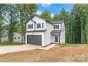 Front view of a two-story house featuring white siding and a gray garage door at 180 Bowman Rd, Statesville, NC 28625