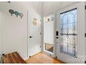 Welcoming entryway featuring a decorative glass door and white paneled walls with warm hardwood flooring at 204 Riverview Ter, Lake Wylie, SC 29710
