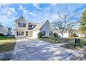 Two-story house with a beige exterior, attached garage, and driveway at 8436 Dawson Ln, Locust, NC 28097