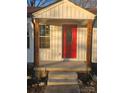 Renovated front entry with red door and wooden posts at 104 Rice St, Kannapolis, NC 28081