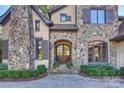 Elegant entryway with a stone facade and a double wooden door at 1105 Hadley Park Ln, Weddington, NC 28104