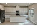 This kitchen features a large island, stainless steel appliances, granite countertops and white cabinets at 116 Sentinel Ct, Mooresville, NC 28115