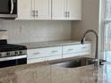 Kitchen featuring stainless steel appliances, granite countertops, tile backsplash, and white cabinets at 116 Sentinel Ct, Mooresville, NC 28115