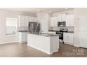 Modern kitchen with white cabinets, granite countertops, and stainless steel appliances at 3266 Maple Ridge Dr, Gastonia, NC 28052