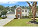 Two-story house with brick and siding, attached garage, and landscaped yard at 7724 Autumnview Ct, Huntersville, NC 28078