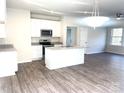 Open concept kitchen with island and wood-look flooring at 115 Venus Ave, Gastonia, NC 28052