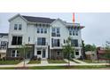 Modern townhouse showcasing a white exterior, black trim, a cozy balcony, and a well maintained front yard at 1229 E 34Th St # Csw0421, Charlotte, NC 28205