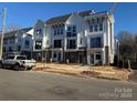 New townhomes showcase brick accents, white siding, and black balconies, with street parking available at 1229 E 34Th St # Csw0421, Charlotte, NC 28205