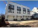 Exterior view of new construction townhomes featuring white garages, charcoal accents and light colored brick foundations at 1229 E 34Th St # Csw0421, Charlotte, NC 28205