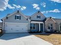 Beautiful single-story home with a two car garage, light blue siding and a well-manicured lawn at 3111 Vermillion Dr, Harrisburg, NC 28075