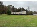 Tan mobile home with wooden steps and surrounding yard at 34&20 Shorty Miller Rd, Taylorsville, NC 28681