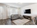 Spacious living room with gray sectional sofa, large TV, and wood-look floors at 40 Harvest Ridge Dr, Hickory, NC 28601