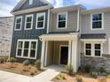 Charming two-story townhome featuring a welcoming front porch and a combination of horizontal siding and stacked stone at 4121 Walking Ridge Rd # 54, Charlotte, NC 28208