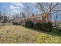 Brick ranch house with a yard, trees, and a fence at 437 Brevard St, Statesville, NC 28677