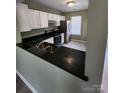 Modern kitchen with dark countertops, stainless steel appliances, and white cabinets at 6353 Windsor Gate Ln, Charlotte, NC 28215