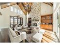 Bright living room featuring a stone fireplace, wood ceiling beams, and hardwood floors at 9809 Saddle Ave, Waxhaw, NC 28173