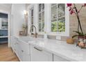 White farmhouse sink, quartz countertops, and light-colored backsplash at 1021 Three Lakes Trl, Waxhaw, NC 28173