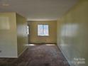 A cozy living room with neutral walls and carpet, perfect for relaxing or entertaining guests at 1608 Carfax Dr, Charlotte, NC 28216
